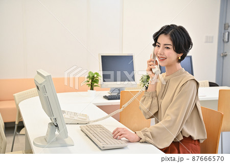 オフィースで電話をする女性 オフィースで電話をする女性 87666570
