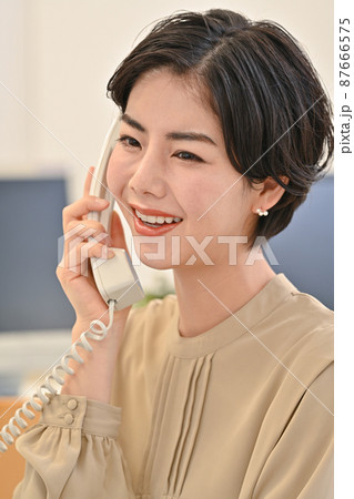 オフィースで電話をする女性 87666575