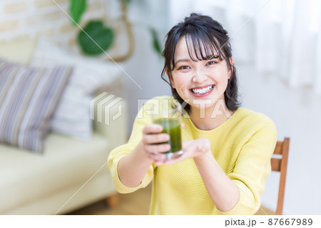 健康のため青汁を飲む若い女性 87667989