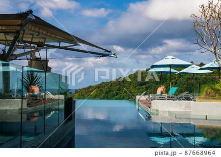 Fit foreign man get sunbath on bed chair of swimming pool Fit foreign man get sunbath on bed chair of swimming pool 87668964