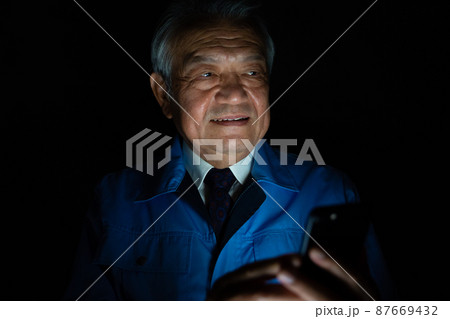 作業着　男性　スマホ　悪巧み 87669432