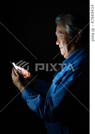 作業着　男性　スマホ　悪巧み 87669434