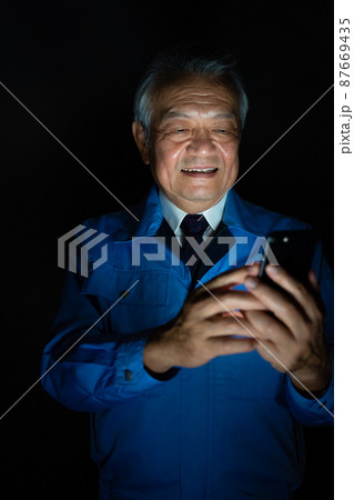 作業着　男性　スマホ　悪巧み 87669435