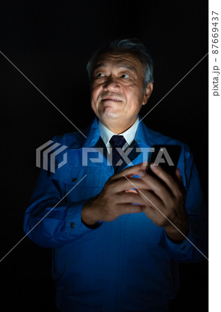 作業着　男性　スマホ　悪巧み 87669437