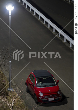 街灯の下に停めた赤いインポートカー 87669638
