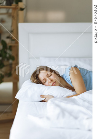 Portrait of young woman enjoying sleeping time in bed , close up ,elevated view, hugging pillow. Portrait of young woman enjoying sleeping time in bed , close up ,elevated view, hugging pillow. 87670302