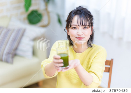 健康のため青汁を飲む若い女性 87670486