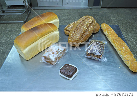 Dutch bakery products placed on a tray: bread, rolls, muffins, machines of an automatic dough line on the background 87671273