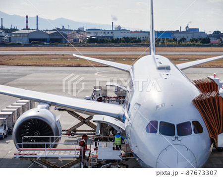飛行場で貨物を搭載中の飛行機 87673307