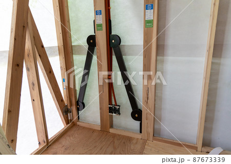 新築一戸建ての工事現場の耐震金具のついた柱 新築一戸建ての工事現場の耐震金具のついた柱 87673339