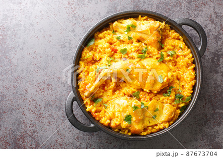 Fragrant rice with vegetables and rabbit meat close-up in a frying pan. horizontal top view 87673704