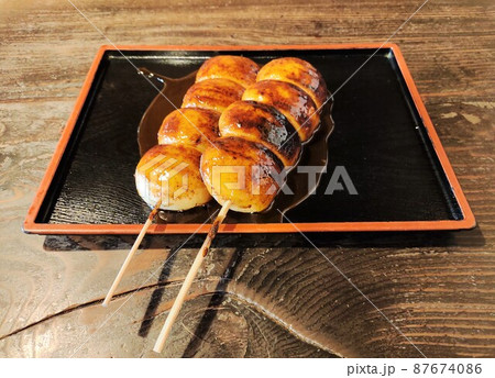 上州名物のおいしそうな焼きまんじゅうが二本テーブルの上に置かれている 87674086