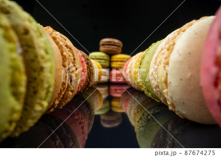 Colored macaroons confectionery marshmallows on a black reflective background in perspective. Extreme macro. 87674275
