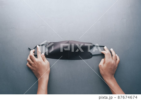 holding a black color cloth face masks top view  87674674