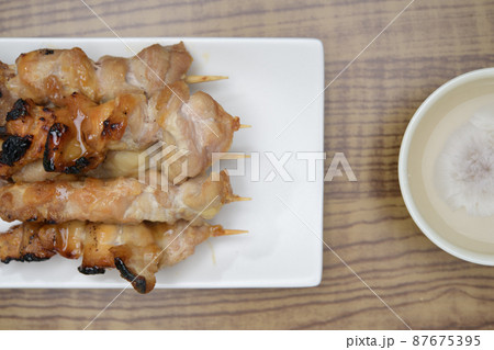 焼き鳥_横写真_俯瞰構図_複数_左配置_薄木目背景_おちょこ添え 87675395