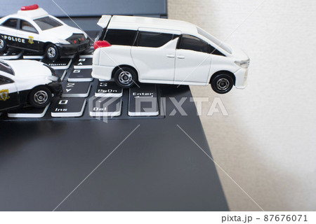 黒いキーボードと2台のパトカーと白いミニバン 87676071