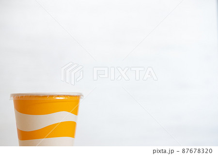 Yellow and white striped plastic cup for soft drinks with copy space Yellow and white striped plastic cup for soft drinks with copy space 87678320