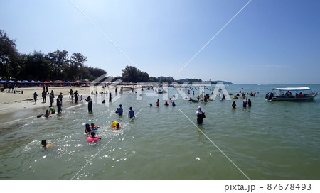 PORT DICKSON, MALAYSIA -MAY 09, 2021: Port Dickson beach is one of the famous tourist spots in Malaysia. Be the focus of people for recreation and water activities.  87678493