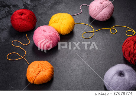 Colorful balls of wool on concrete table. Variety of yarn balls 87679774