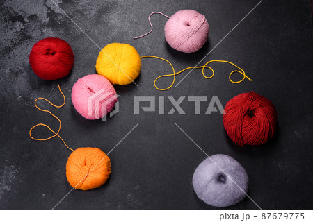 Colorful balls of wool on concrete table. Variety of yarn balls 87679775