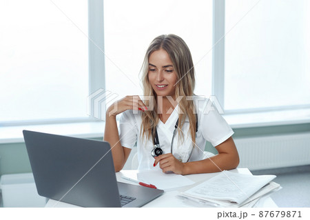 Portrait of a smiling woman doctor, consult patient client online, medicine and technology concept 87679871