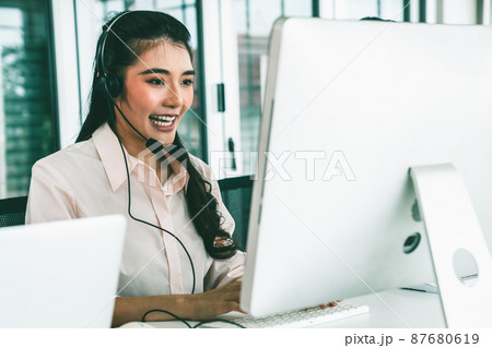 Businesswoman wearing headset working actively in office 87680619