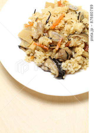 鶏五目炊き込みご飯、白い皿に盛られた五目ご飯、白木木目バック 鶏五目炊き込みご飯、白い皿に盛られた五目ご飯、白木木目バック 87680789