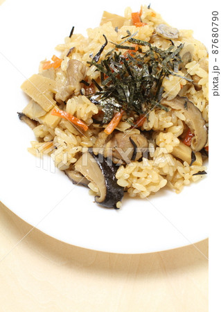 鶏五目炊き込みご飯、白い皿に盛られた五目ご飯、白木木目バック 鶏五目炊き込みご飯、白い皿に盛られた五目ご飯、白木木目バック 87680790