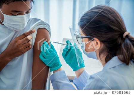 Young man visits skillful doctor at hospital for vaccination 87681665