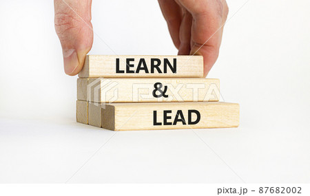 Learn and lead symbol. Concept words 'Learn and lead'. Businessman hand. Beautiful white background. Business, educational and learn and lead concept, copy space. 87682002