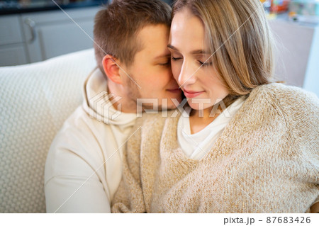 a happy and loving couple at home on the couch a happy and loving couple at home on the couch 87683426