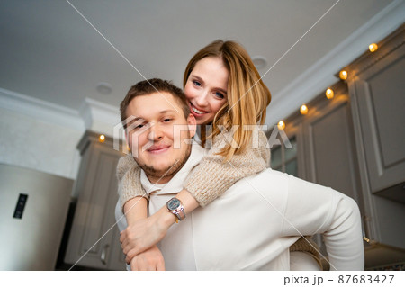 a happy and loving couple fooling around and hugging at home in the kitchen a happy and loving couple fooling around and hugging at home in the kitchen 87683427