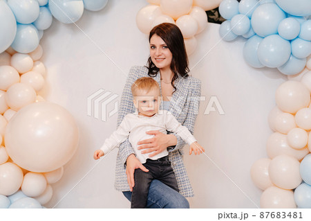 happy mom and son in front of the photo zone with balloons 87683481