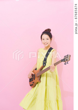 女性　ギタリスト　ピンク背景 87685874