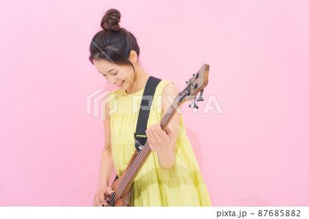 女性　ギタリスト　ピンク背景 87685882