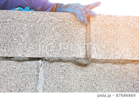 Technician building a brick wall at a construction site Technician building a brick wall at a construction site 87686869
