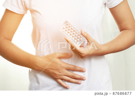 Woman hands opening birth control pills in hand. eating Contraceptive pill. Contraception reduces childbirth and pregnancy concept. 87686877