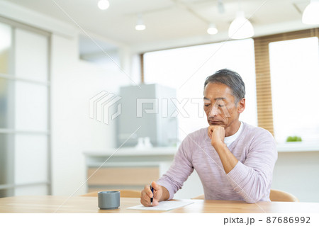 手紙を書くシニア男性 87686992