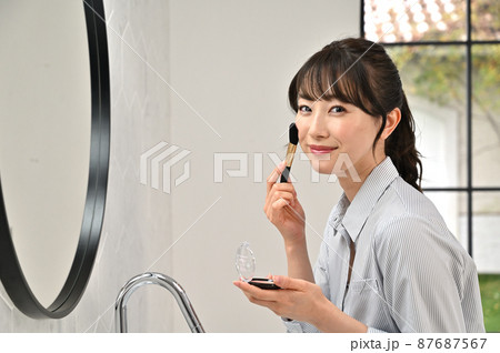 鏡の前でお化粧をする女性 鏡の前でお化粧をする女性 87687567