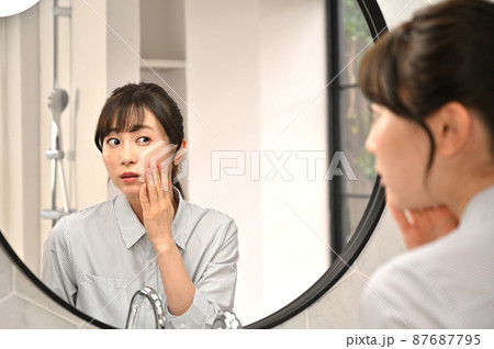 鏡の前でお肌のチェックをする女性 87687795
