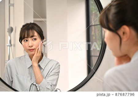 鏡の前でお肌のチェックをする女性 87687796