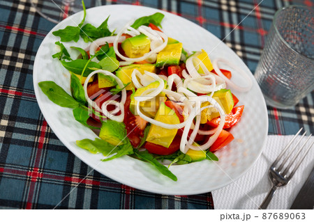 Salad with fresh tomatoes, avocado, onion and herbs Salad with fresh tomatoes, avocado, onion and herbs 87689063
