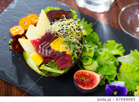 Close up of tasty salad of raw tuna, avocado, mango and greens Close up of tasty salad of raw tuna, avocado, mango and greens 87689065
