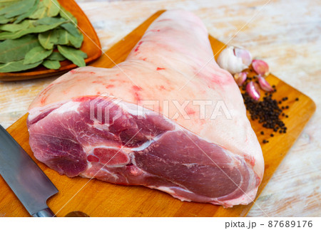 Raw pork leg with herbs and condiments ready for cooking 87689176