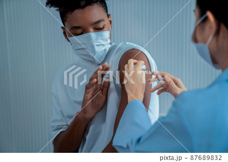 Young man visits skillful doctor at hospital for vaccination 87689832