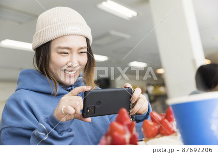 スキー場のカフェスペースでスイーツの写真を撮る若い女性 87692206