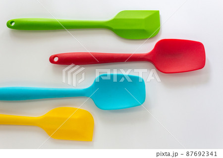 Silicone spatulas in various color, red, blue, green and yellow lay on white background 87692341