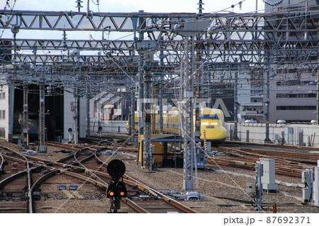 新大阪駅ホームから見て入り組んだポイントを通過するドクターイエロー 87692371