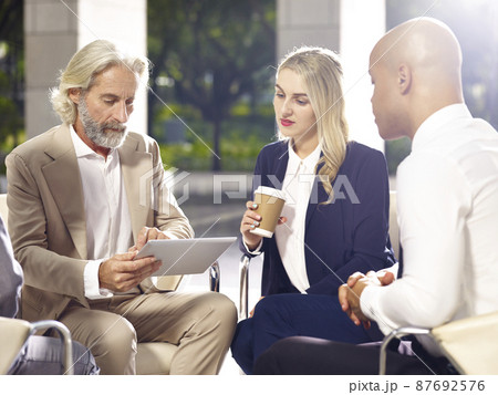 multiethnic coporate people meeting discussing business using digital tablet in modern building 87692576