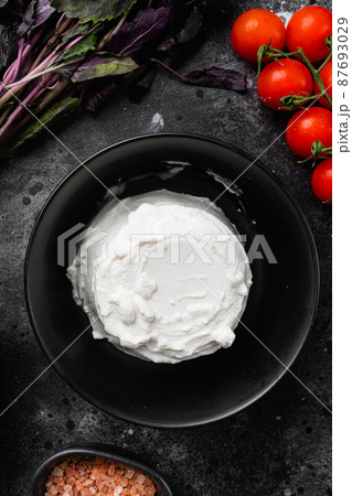 A fresh ricotta, on black dark stone table background, top view flat lay A fresh ricotta, on black dark stone table background, top view flat lay 87693029